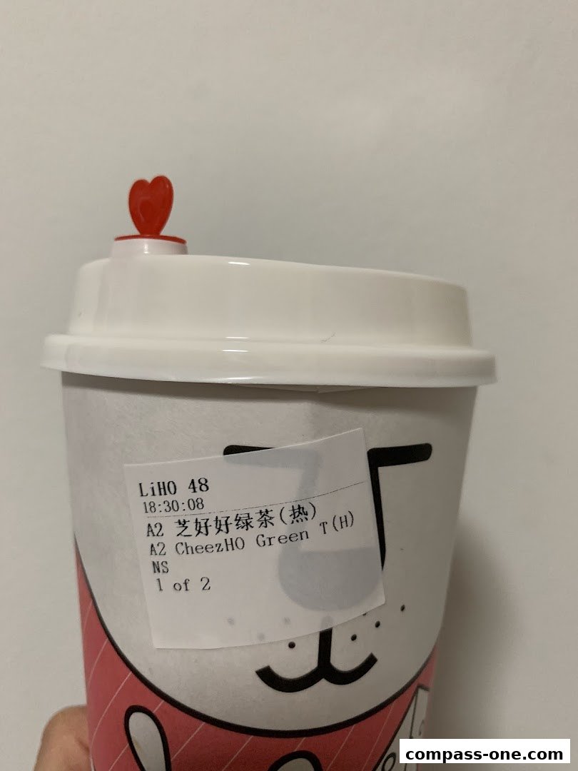 A close-up of a LiHO TEA cup with a sticker showing order details.