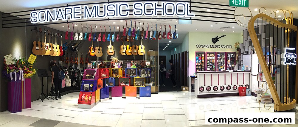 The entrance of Sonare Music School, showcasing guitars, violins, and a reception area.