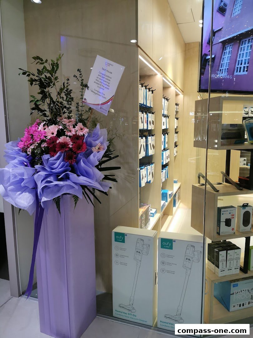 A shop front with a floral arrangement and boxes of vacuum cleaners displayed.