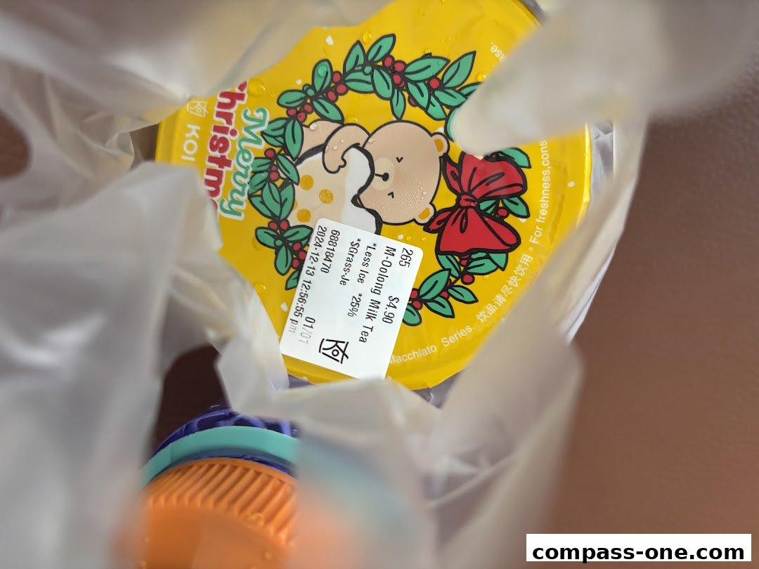 A KOI Thé drink with a festive Christmas-themed lid and a receipt attached.