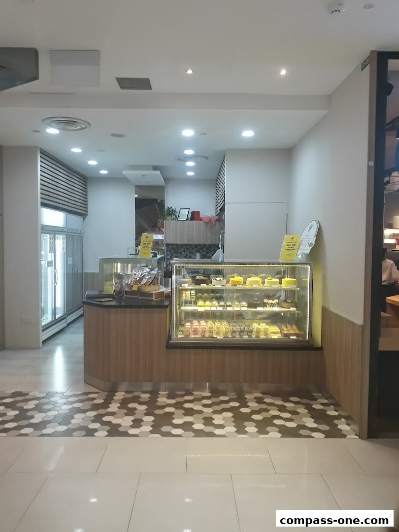 A display of various cakes and pastries in a refrigerated showcase at Emicakes.