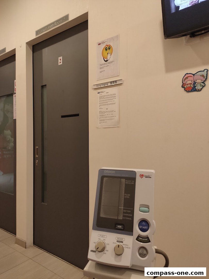 A consultation room door with a blood pressure monitor and informational signs on the wall.