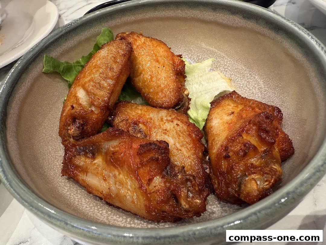 A bowl of crispy, golden-brown chicken wings served with lettuce.