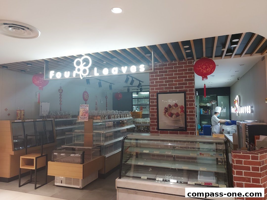Interior view of a bakery shop with display cases and a staff member.
