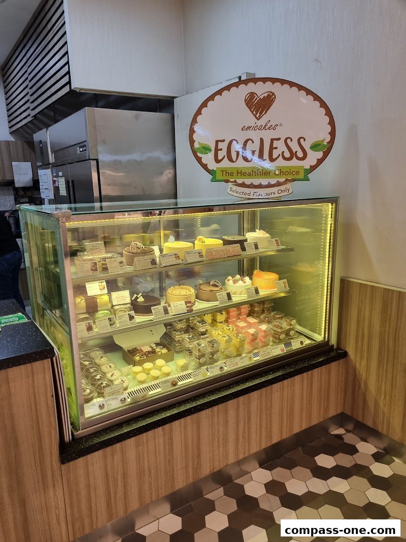 A display case filled with various cakes and pastries at Emicakes.