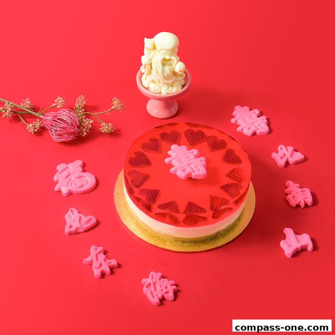 A festive cake with strawberry jelly and pink Chinese characters on a red background.