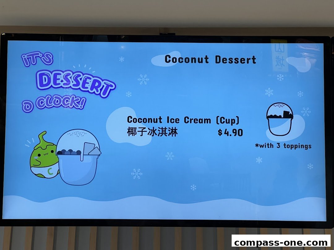 A digital menu board displaying a coconut ice cream dessert with price and toppings.
