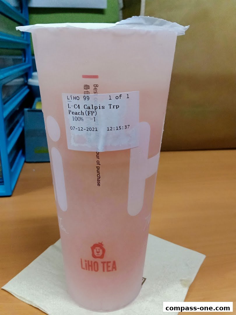 A LiHO TEA cup with a peach-flavored drink and a label showing order details.