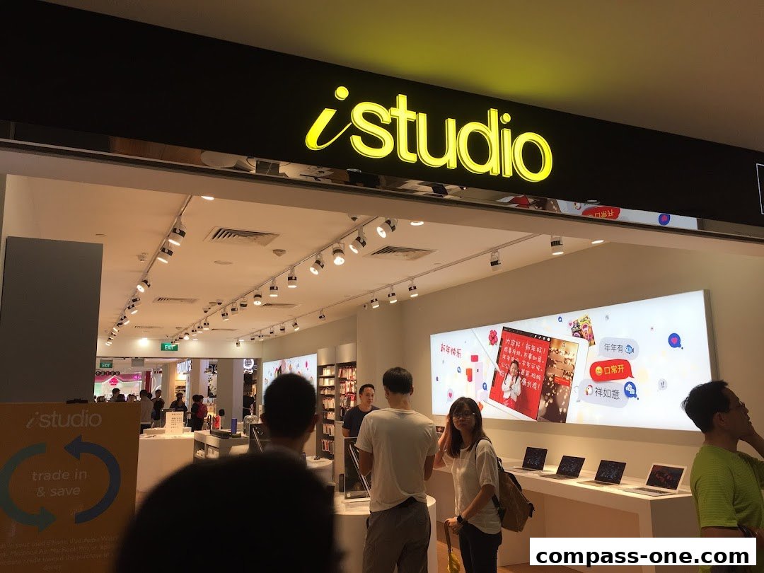 The entrance of an iStudio electronics store with Apple products displayed.