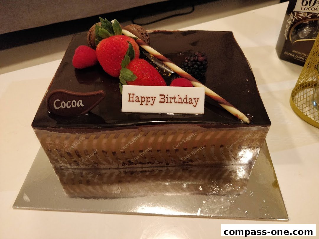 A decadent chocolate cake decorated with fresh berries and a 'Happy Birthday' message.
