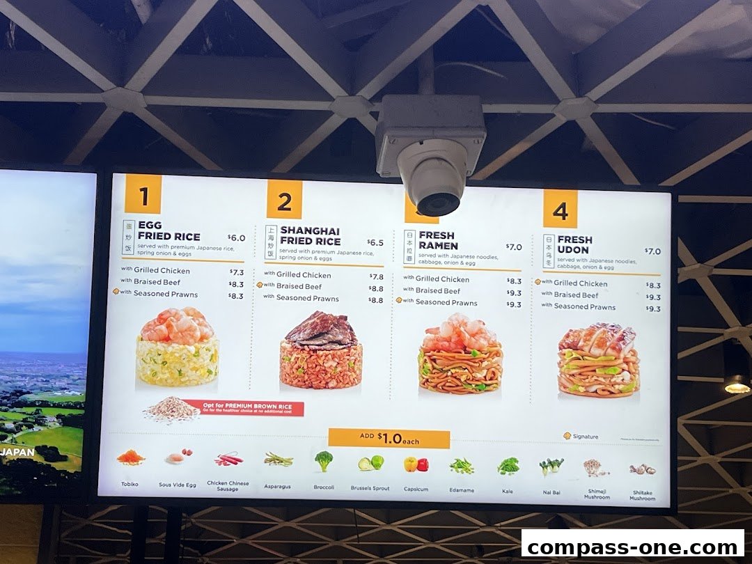 A digital menu board displaying various rice, ramen, and udon dishes with customization options.