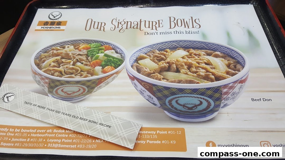 Two bowls of Yoshinoya's signature beef bowls, one with vegetables and one with onions.