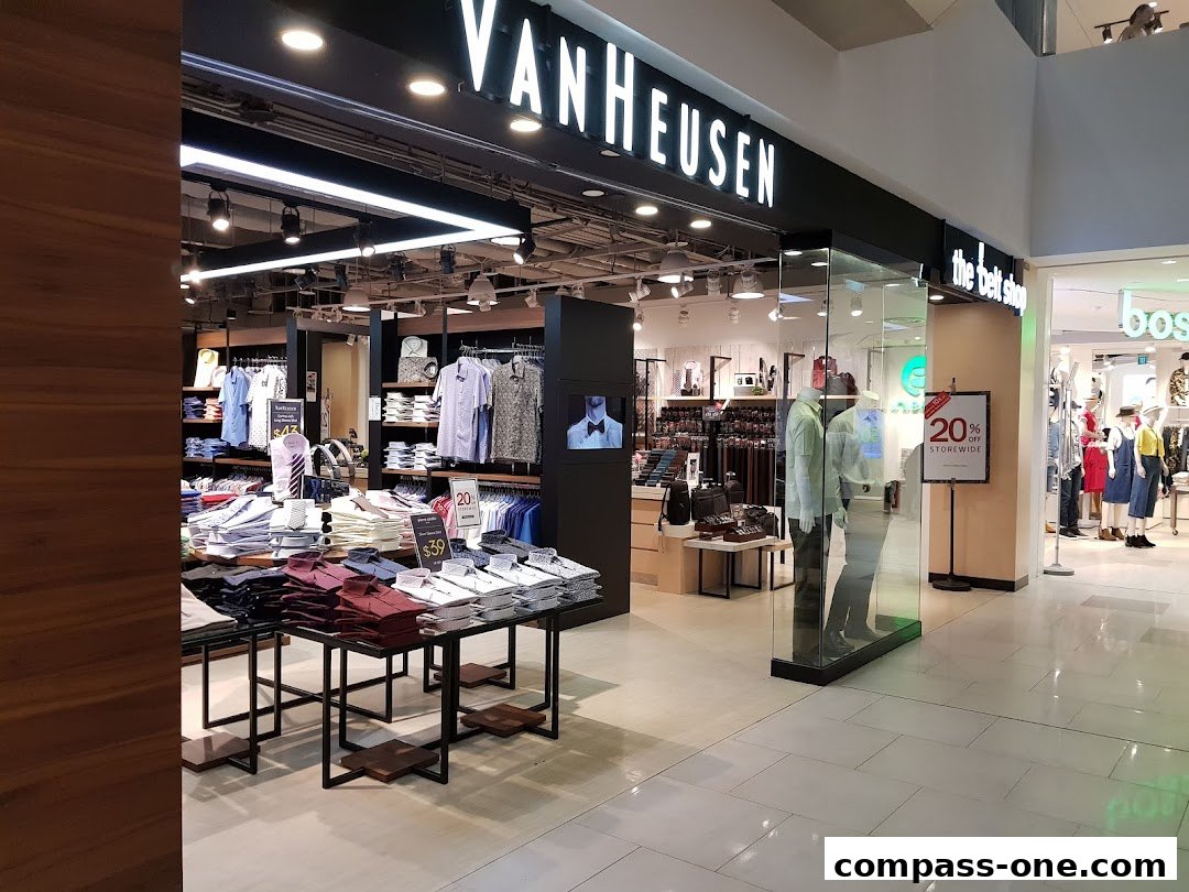 Van Heusen store interior showcasing men's shirts and a 20% off storewide sale.