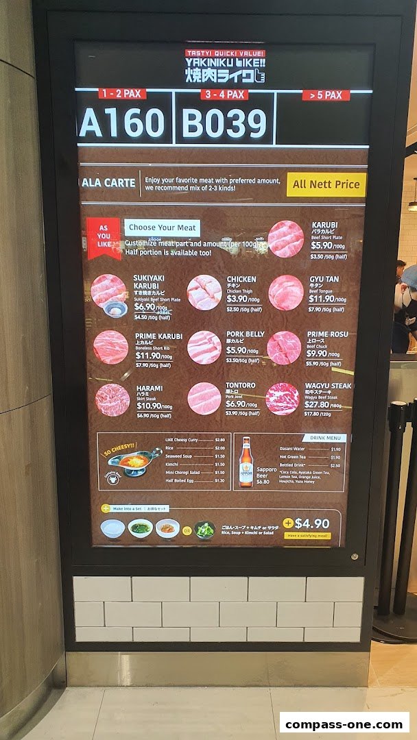 A digital menu board displaying various cuts of meat for yakiniku, with prices and descriptions.