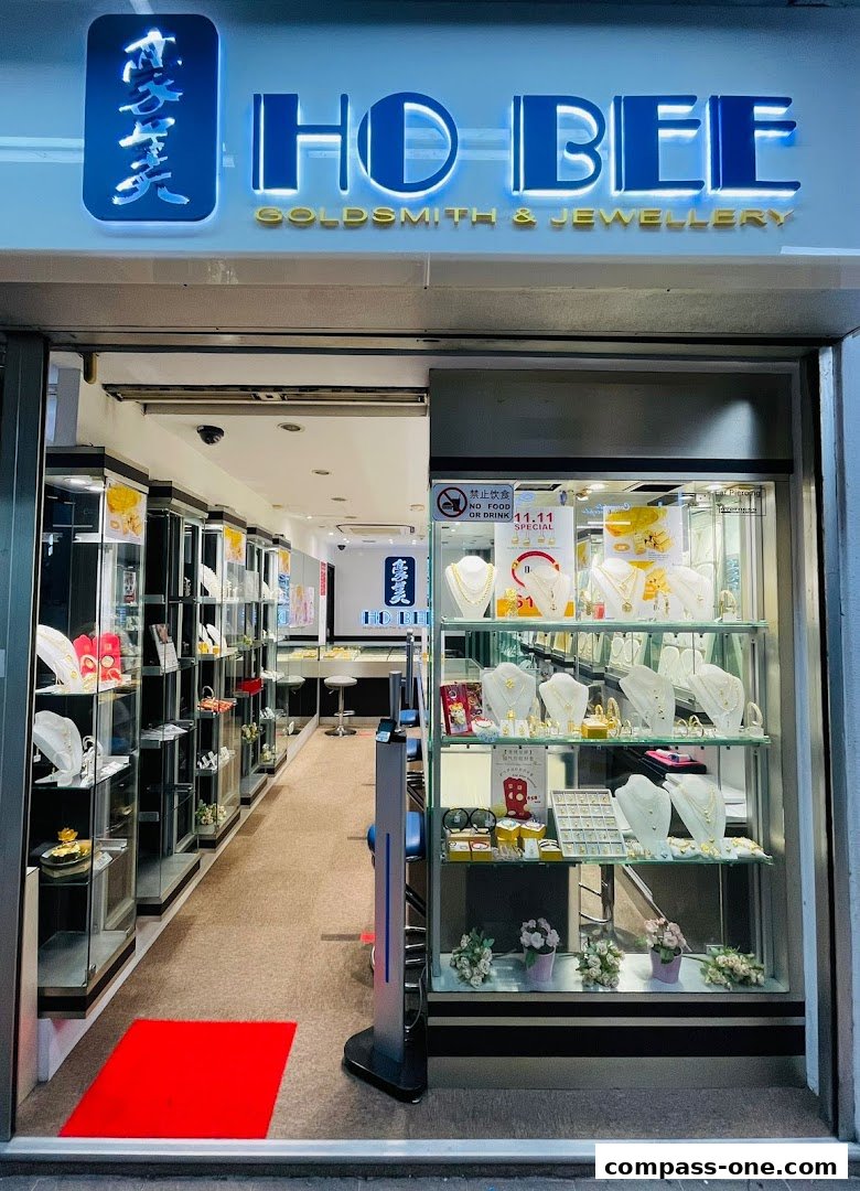 The entrance of Ho Bee Goldsmith & Jewellery, showcasing display cases filled with various jewelry items.