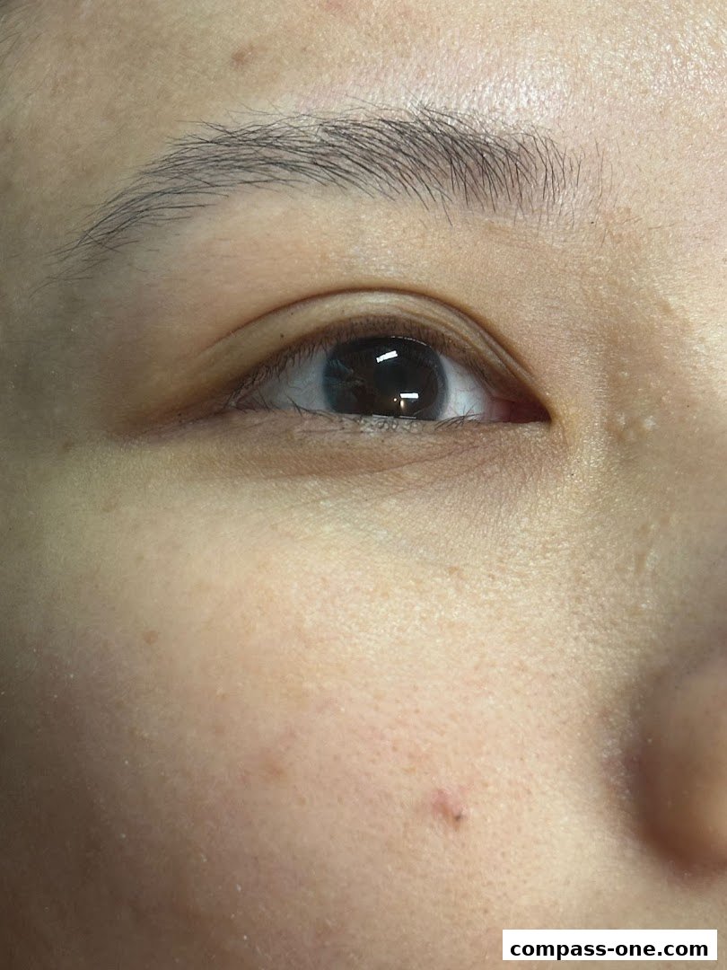 Close-up of a person's eye and eyebrow, showcasing skin texture.