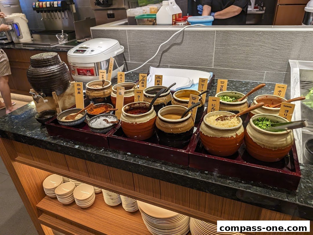 A variety of sauces and condiments are displayed in ceramic pots with labels.