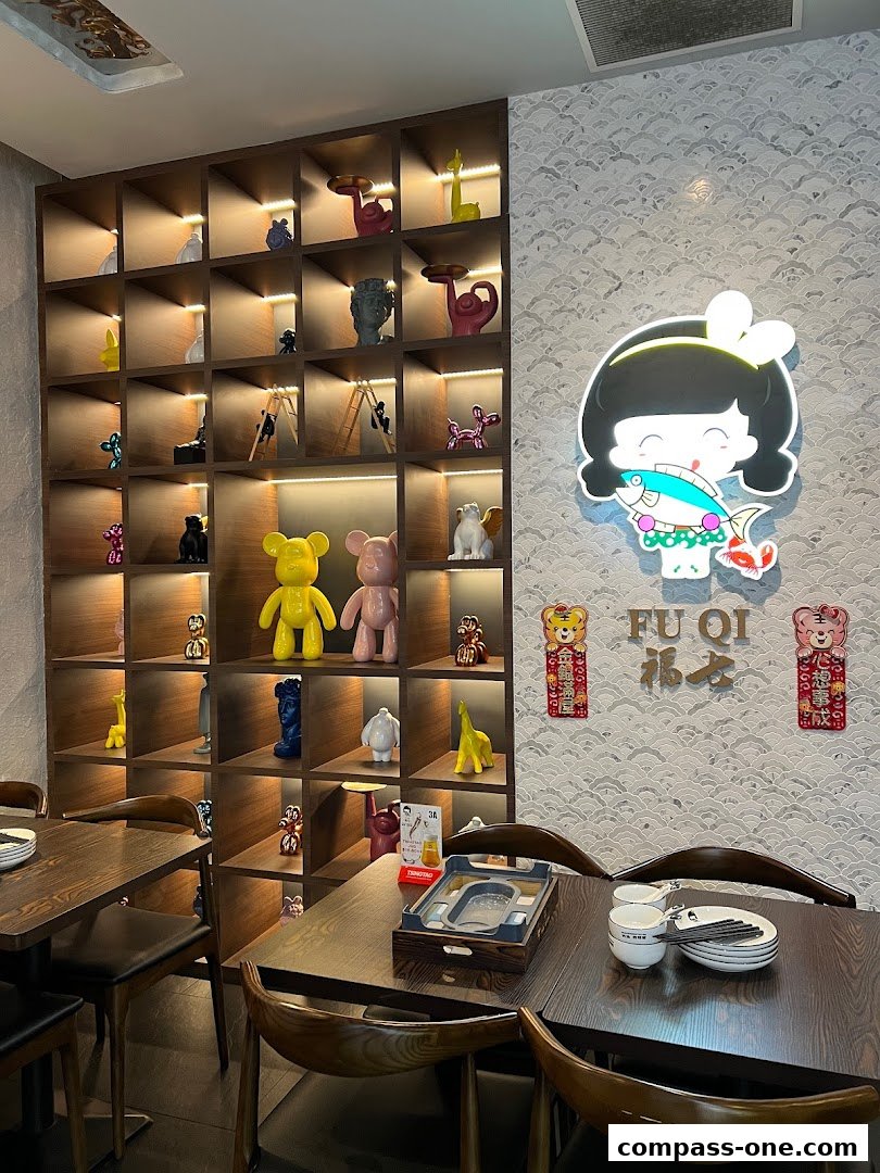 Interior of Fu Qi Grilled Fish restaurant with decorative shelves and dining tables.