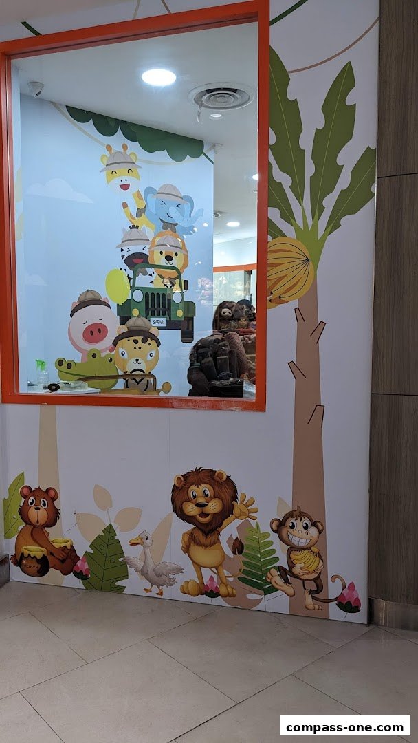 A shop window decorated with cartoon safari animals and jungle foliage.