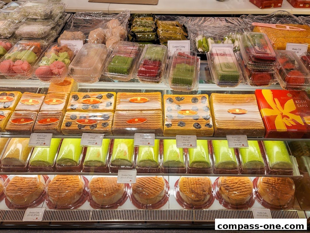 A display of various cakes and pastries, including layered cakes, swiss rolls, and round cakes.
