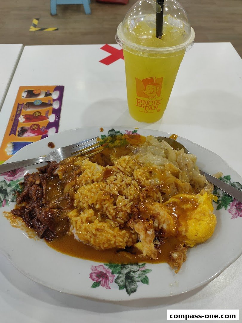 A plate of rice with various toppings and a drink from Encik Tan.