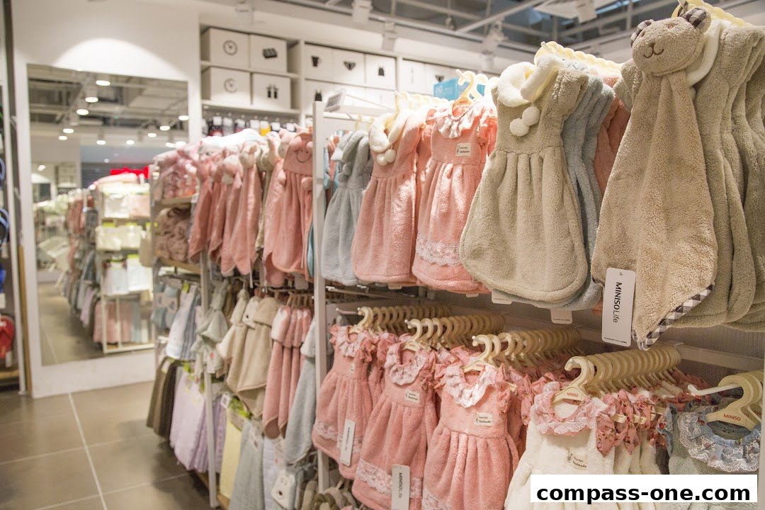 Interior view of a MINISO store showcasing a variety of cute, towel-like products in pastel colors.