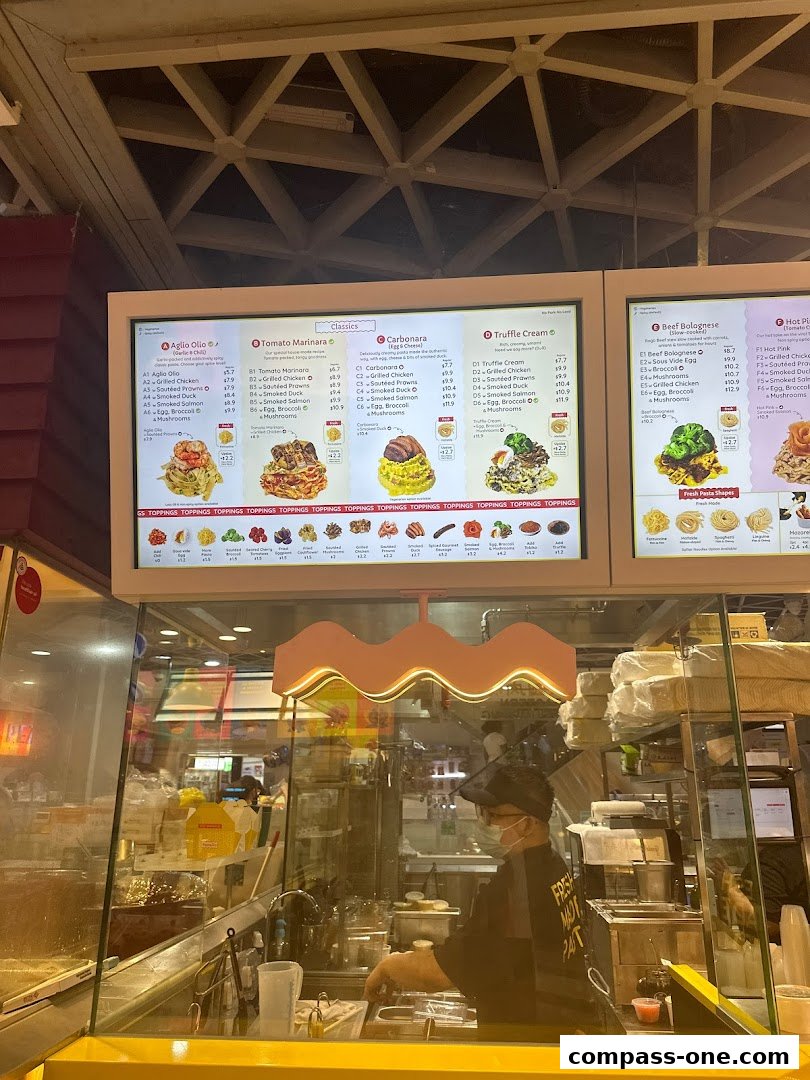 A digital menu board displaying various pasta dishes with toppings and prices.