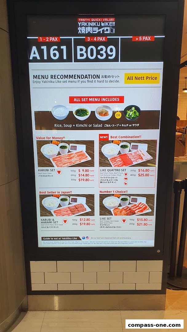 A digital menu board displaying various Yakiniku Like set meals with prices and descriptions.