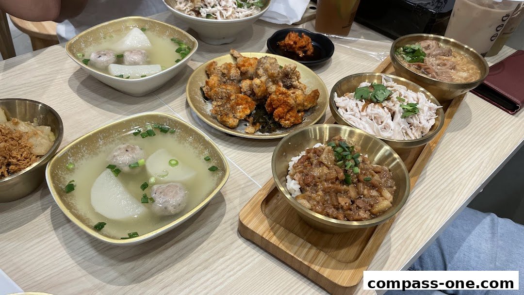 A table filled with various Taiwanese dishes, including soup, fried chicken, and rice bowls.