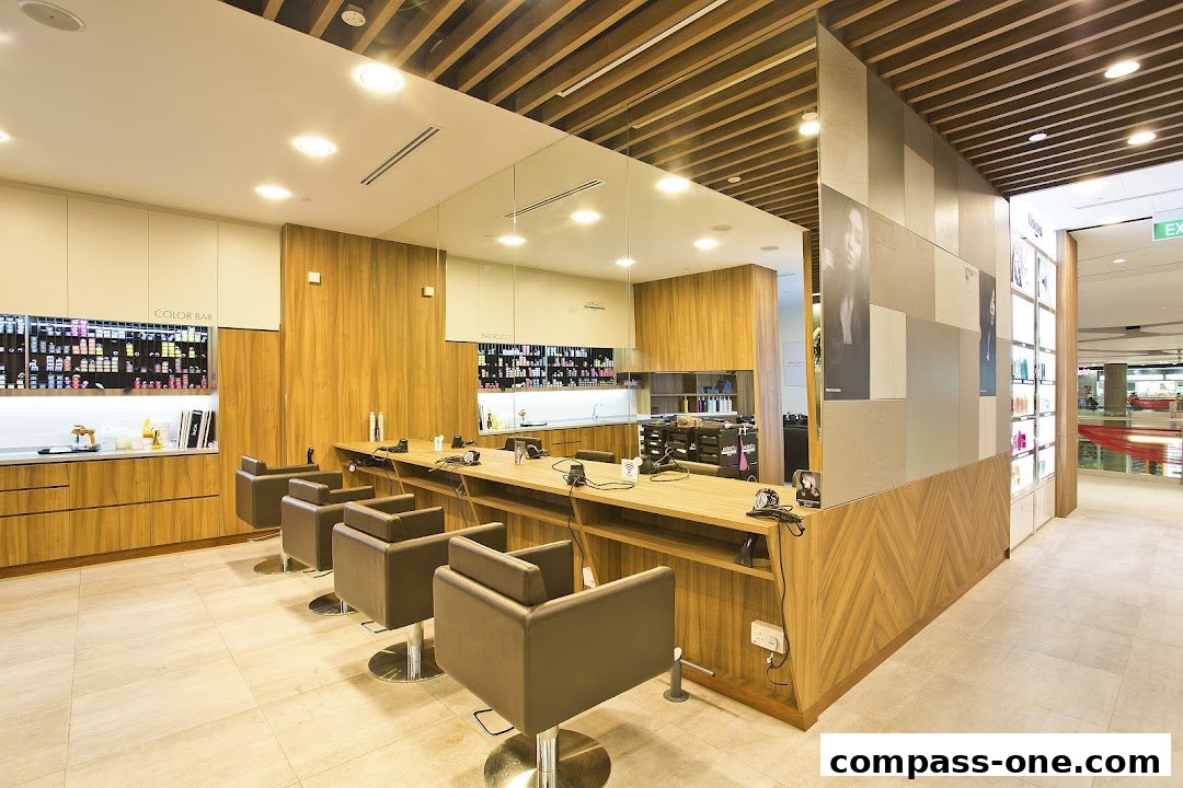 Interior of a modern hair salon with styling chairs, a color bar, and product displays.