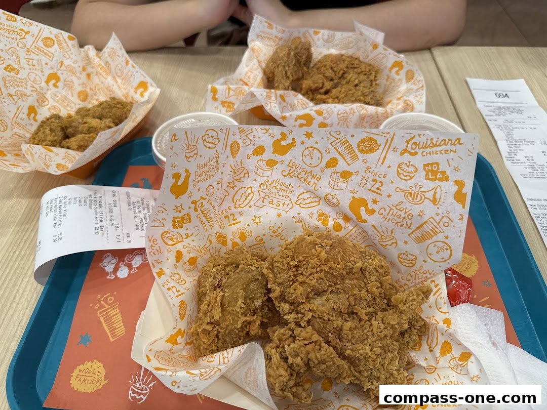 A tray of Popeyes Louisiana Kitchen fried chicken and sides on a table.