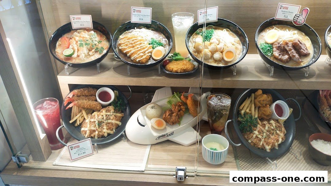 A display case showcasing various delicious ramen dishes and set meals from Ajisen Ramen.