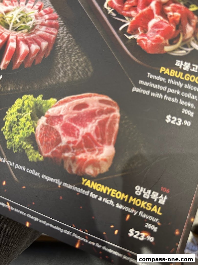 A close-up of a menu featuring Korean BBQ pork dishes with prices.