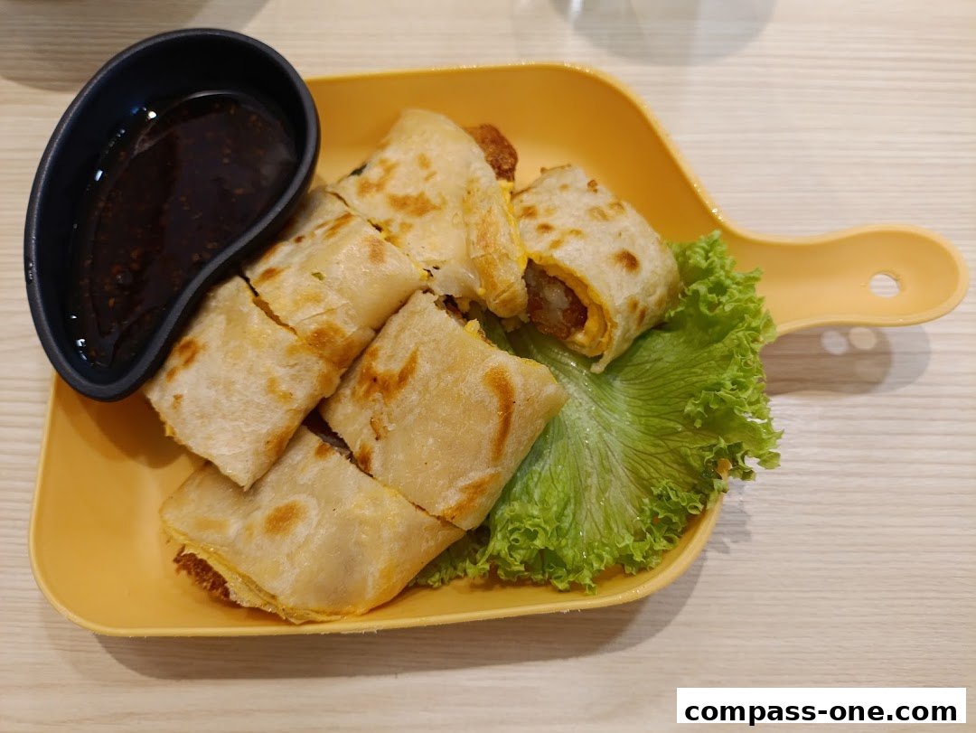 A plate of sliced savory crepes with a side of dipping sauce and lettuce.