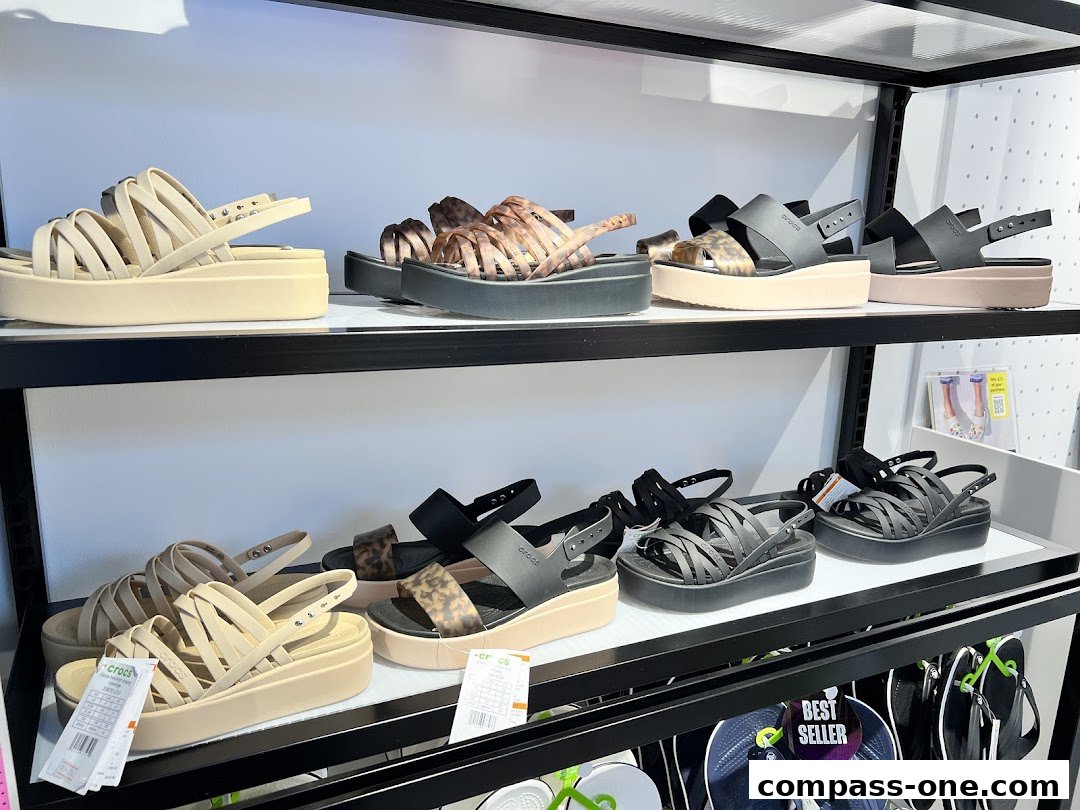 A display of various Crocs sandals on shelves, featuring different styles and colors.