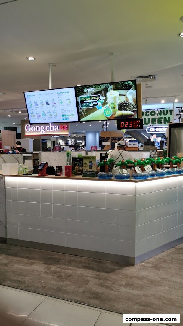 A clean, modern beverage counter with digital menus and decorative palm trees.