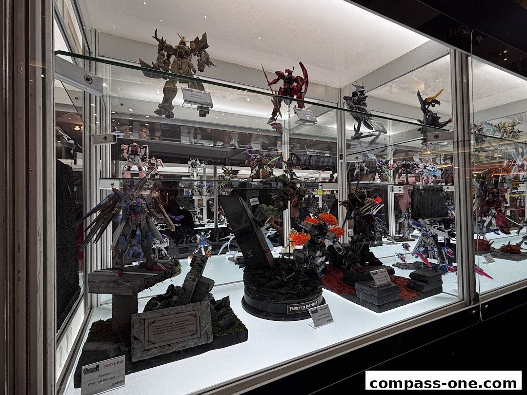 A display case filled with detailed Gundam models and action figures.
