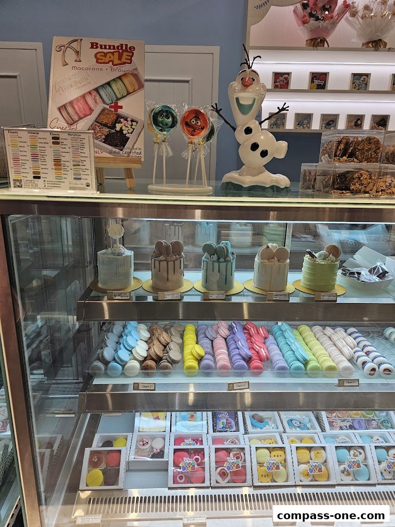 A display case filled with colorful macarons, cakes, and character-themed treats.