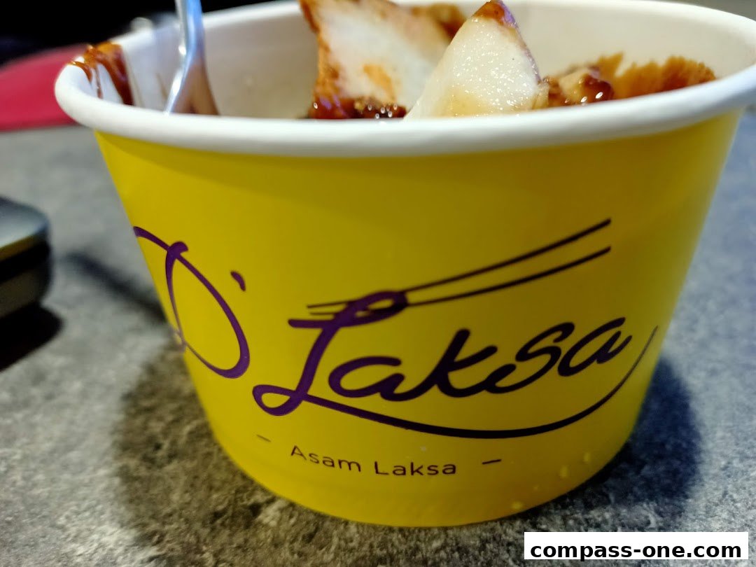 A close-up of a yellow cup with the D Laksa logo and a serving of Asam Laksa.