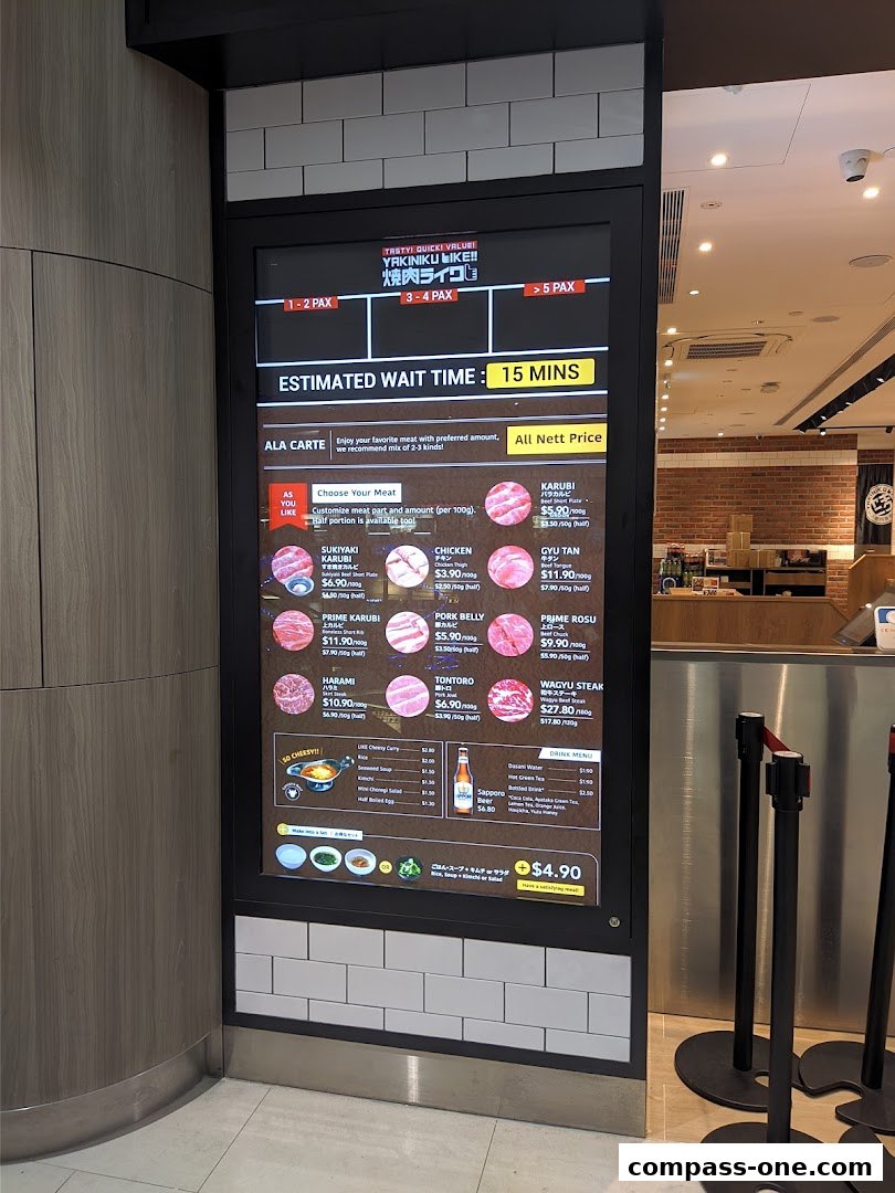 A digital menu board displaying various meat options, prices, and estimated wait times for Yakiniku Like.