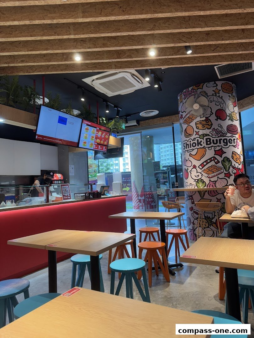 Interior view of Shiok Burger with tables, chairs, and a counter.