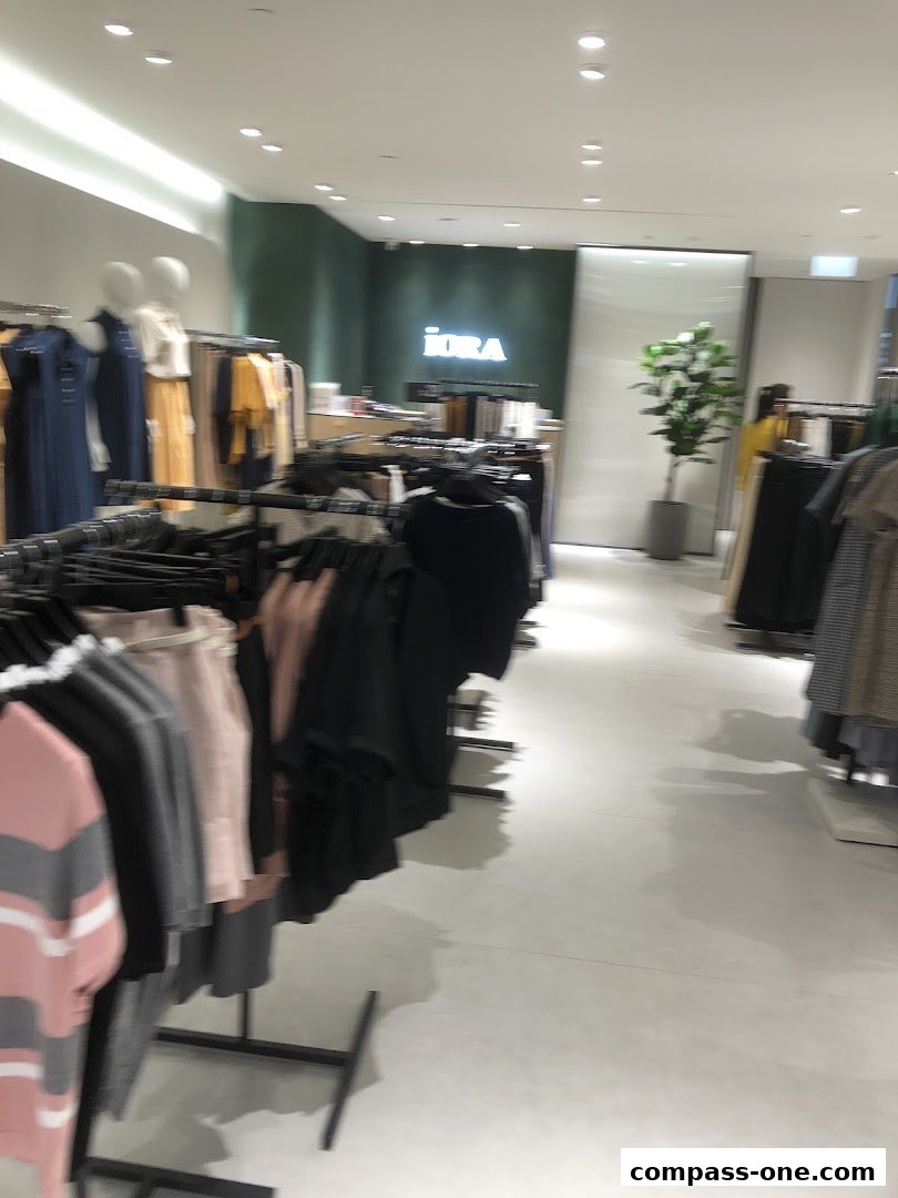 Interior view of a clothing store with racks of apparel and mannequins.