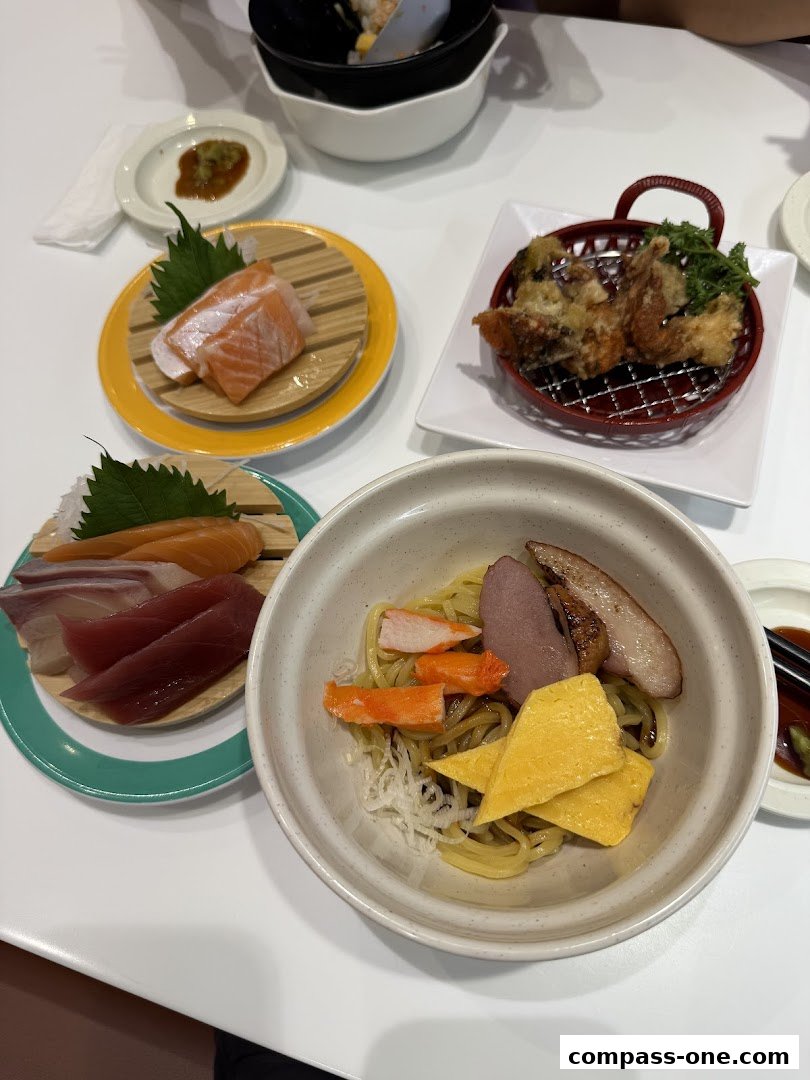A table laden with various Japanese dishes, including sashimi, fried food, and noodles.