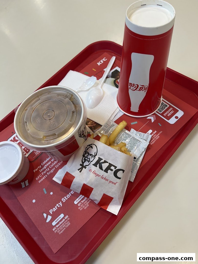 A red KFC tray holds a meal with a drink, fries, and a side dish.