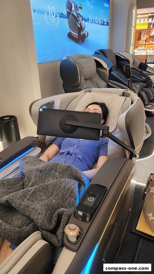 A person relaxing in a massage chair with a screen in front of them.