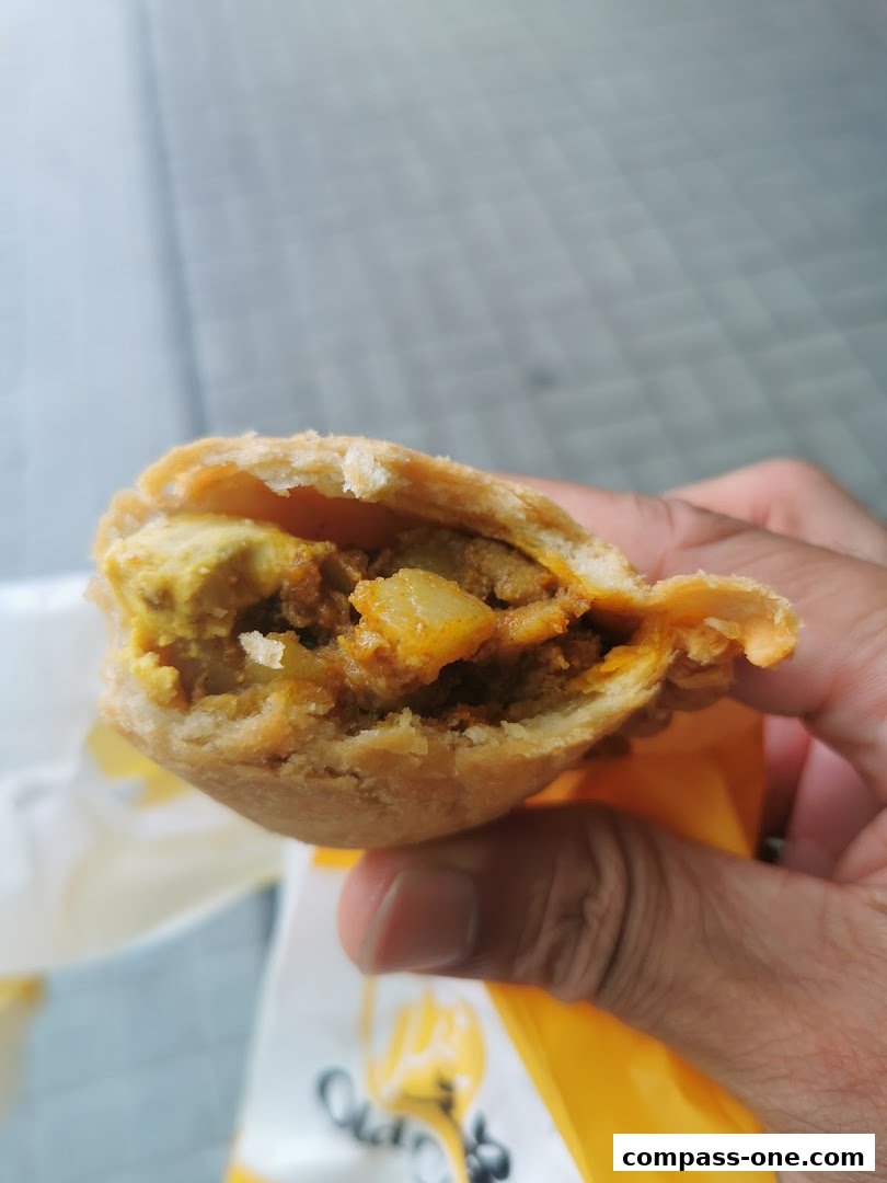 A hand holds a delicious-looking curry puff from Old Chang Kee.
