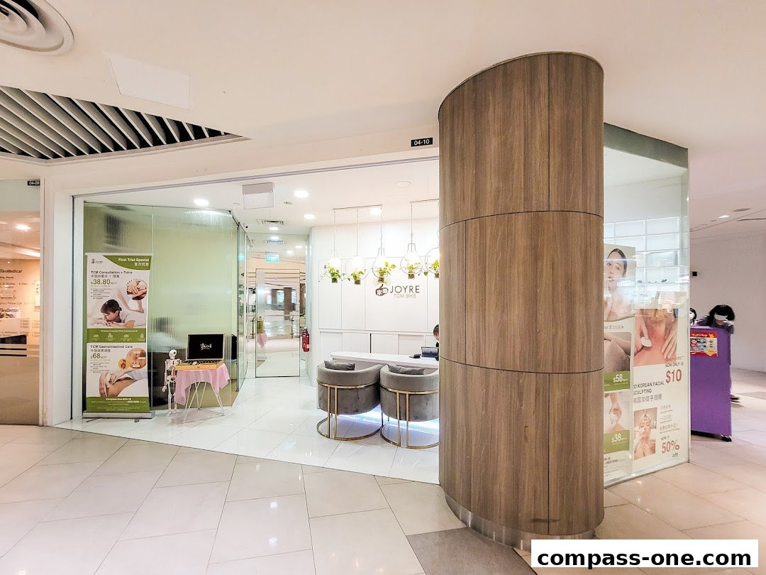 The entrance of Joyre TCMedi Spa, featuring a modern interior and promotional posters.