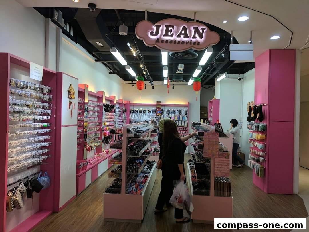 Interior view of a brightly lit accessories shop with pink displays and a wide variety of hair and fashion accessories.
