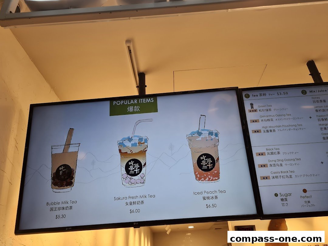 A digital menu board displaying popular bubble tea drinks and tea options.