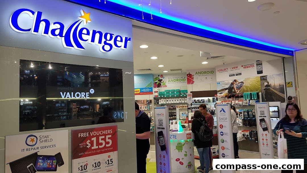 The exterior of a Challenger electronics store with a prominent sign and displays of mobile devices and accessories.